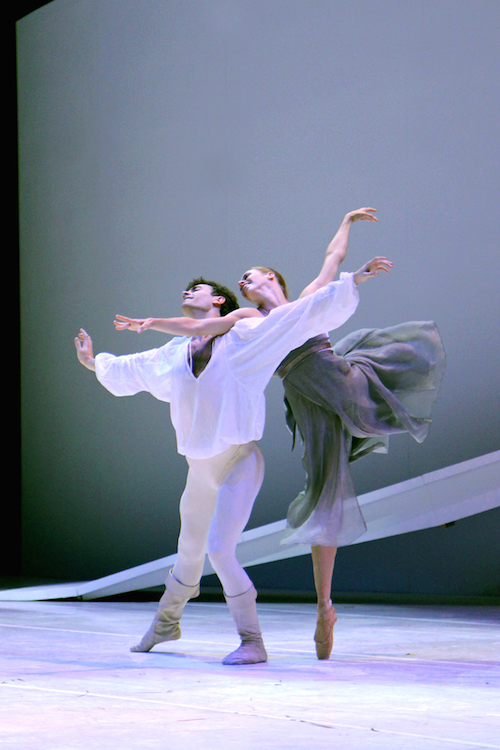 Lesley, in an arabesque on pointe with her right arm supported by Jerome's shoulder